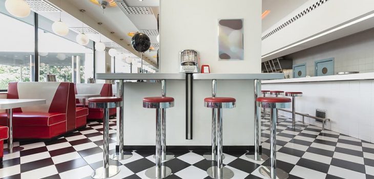 酒吧凳子在一個美國晚餐餐館在棋盤地板上