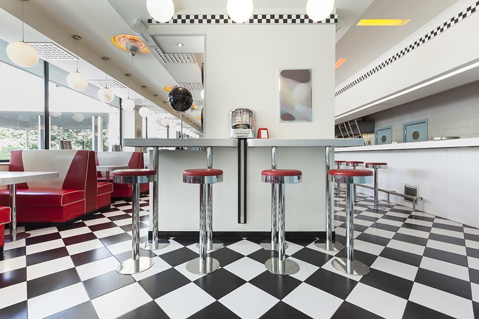美國餐廳裏棋盤式地板上的酒吧凳子