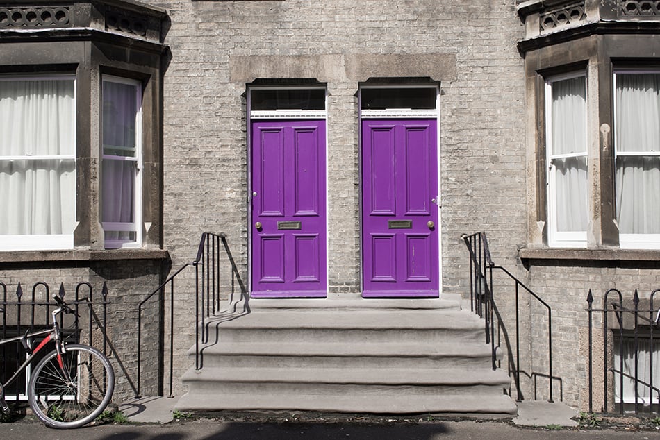灰色外部的兩個相同的紫色木門